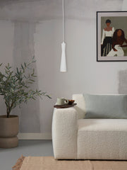 RoMi Hängeleuchte Bordeaux in Weiß aus Eisen: schlanke Pendelleuchte über einem cremefarbenen Bouclé-Sofa.