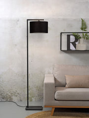 Schwarze Stehleuchte It's about RoMi Boston mit schwarzem Stoffschirm und schmalem Metallgestell, neben beigem Sofa
