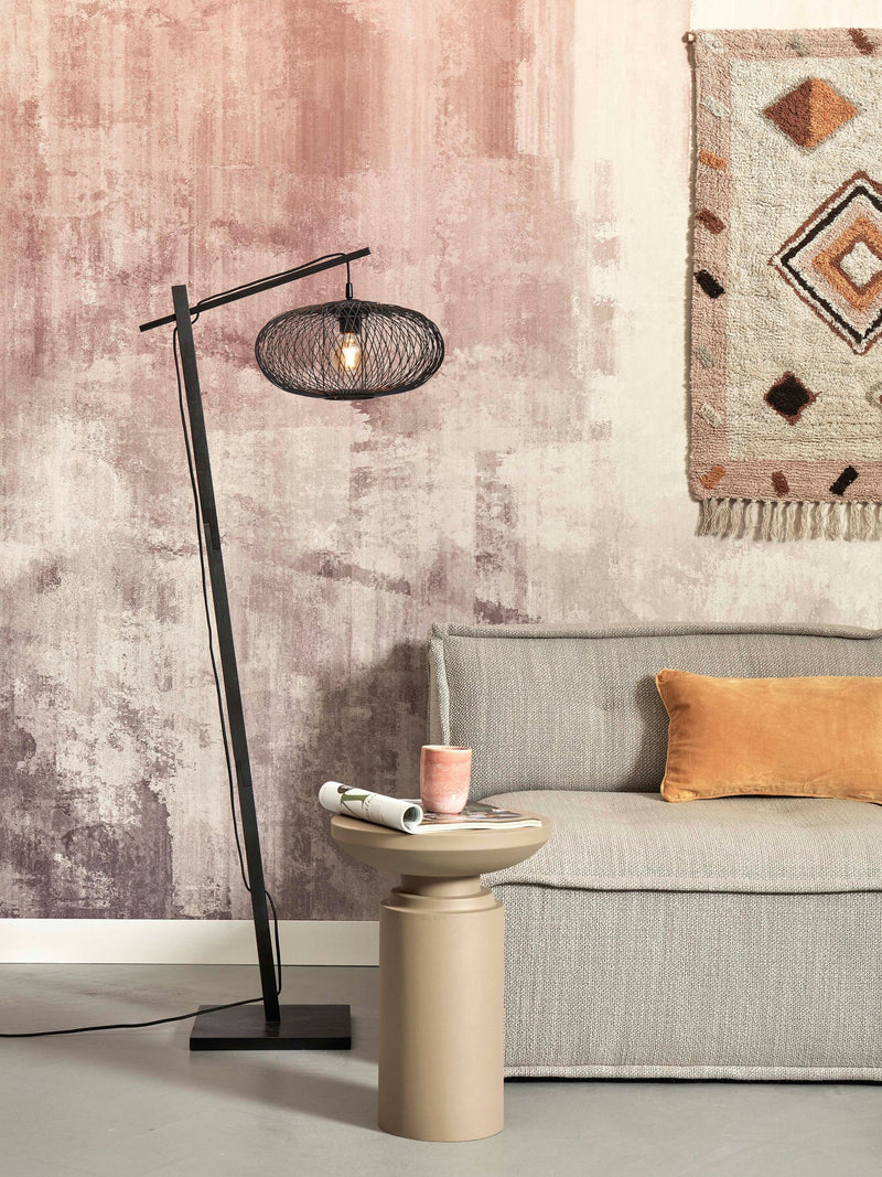 Stehleuchte Cango von Good&Mojo mit schwarzem Bambusgestell und ovalem Geflechtschirm vor rosa-beiger Wand.