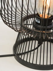 Detailansicht der Good&Mojo Tischleuchte Cango: schwarze Drahtgeflecht-Schirmstäbe und eine Glühlampe mit Fassung im Inneren.