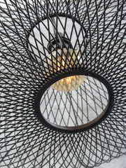 Detailansicht der Good&Mojo Wandleuchte Cango mit schwarzem Bambusgeflecht und sichtbarer Glühlampe im Inneren.