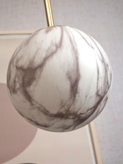 It’s about RoMi Hängeleuchte Carrara: Detailansicht der Glaskugel mit Marmordruck in Weiß und Grau sowie goldener Stange.