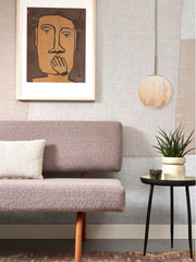 Hängeleuchte It's about RoMi Carrara mit marmorierter Glaskugel über einem Sofa mit Bouclé-Bezug und Wandkunst.