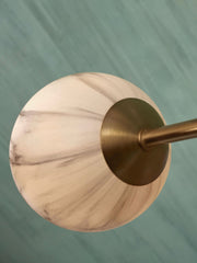 Detailansicht der RoMi Hängeleuchte Carrara: kugelförmiger Glasschirm mit marmoriertem Rauchglas-Muster und goldfarbenem Messingschirm.