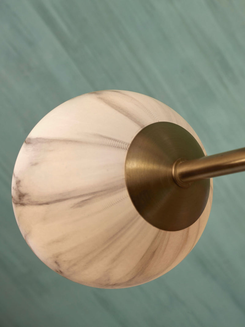 Detailansicht der RoMi Hängeleuchte Carrara: kugelförmiger Glasschirm mit marmoriertem Rauchglas-Muster und goldfarbenem Messingschirm.