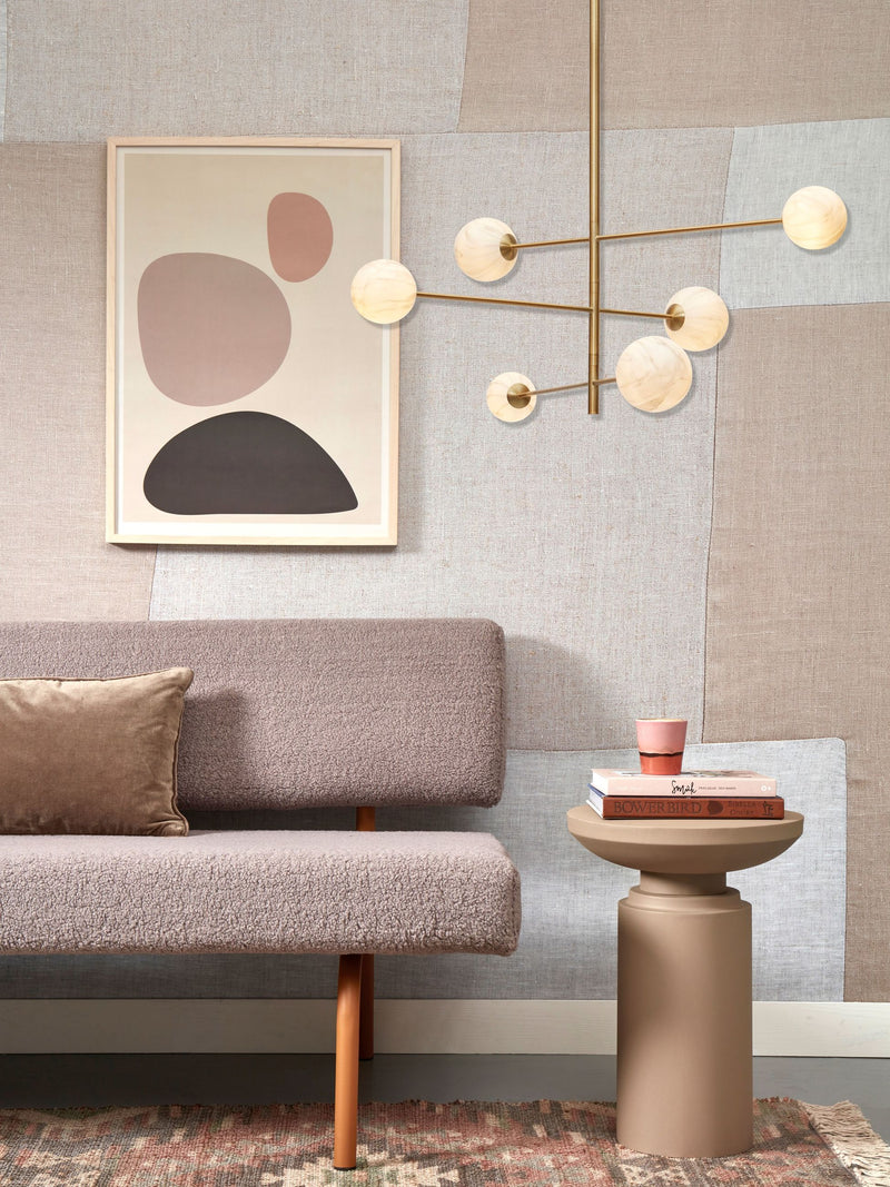 Gesamtansicht: Die Hängeleuchte It's about RoMi Carrara mit sechs weißen Glaskugeln an goldenen Armen über einem Sofa.