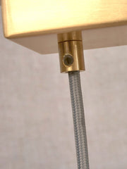 RoMi Hängeleuchte Carrara Glas Gold/Rauchglas, 6-flammig: Detail der goldfarbenen Deckenbefestigung mit grauem Kabel.