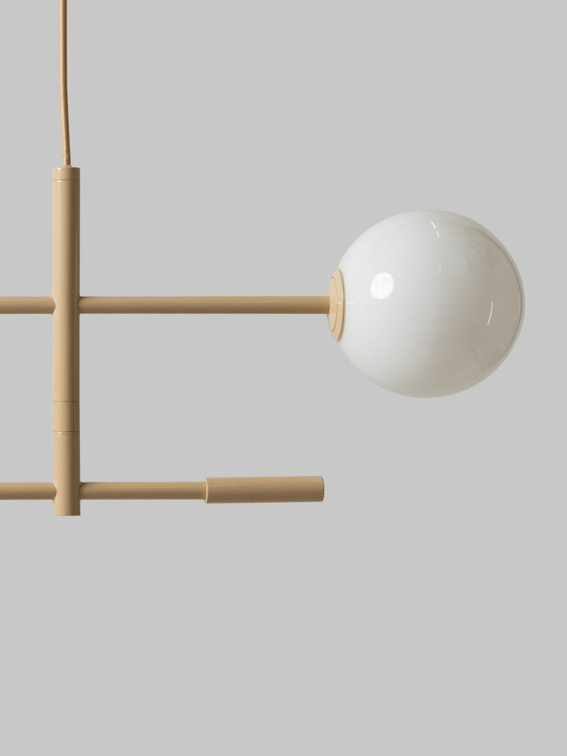 Pendelleuchte RoMi Copenhagen in Beige: Detailansicht mit beigem Eisengestell und weißem Glasschirm vor grauem Hintergrund