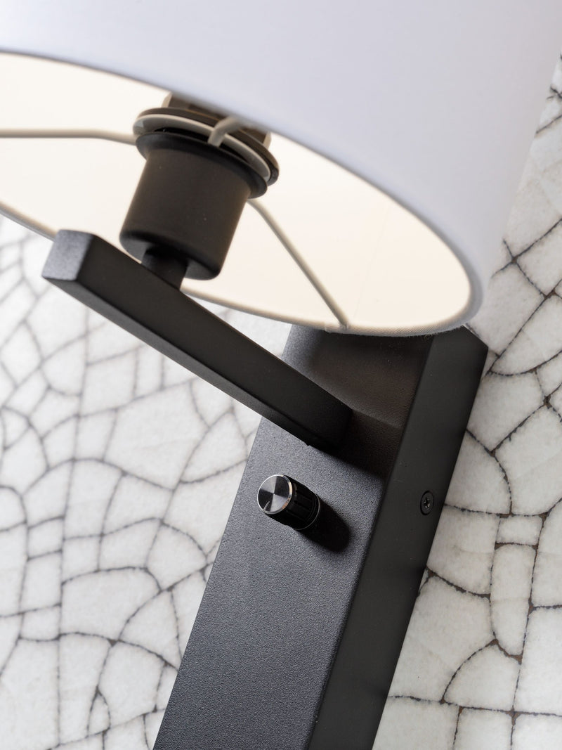 Detailansicht der schwarzen Metallhalterung der Wandleuchte It's about RoMi Florence mit weißem Stoffschirm und Drehschalter.