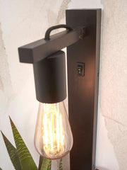 Schwarze Wandleuchte Flores aus Bambus mit Glühbirne im Edison-Stil, Wandschalter und Ablagearm in Nahansicht.