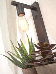 Schwarze Wandleuchte Flores mit Bambusgestell, Glühlampe mit Schalter an der Wandhalterung, Pflanzen im Vordergrund