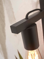 Detailansicht der schwarz lackierten Bambus-Wandleuchte Good&Mojo Flores mit Ablage, Fokus auf Leuchtenkopf und Glühlampe