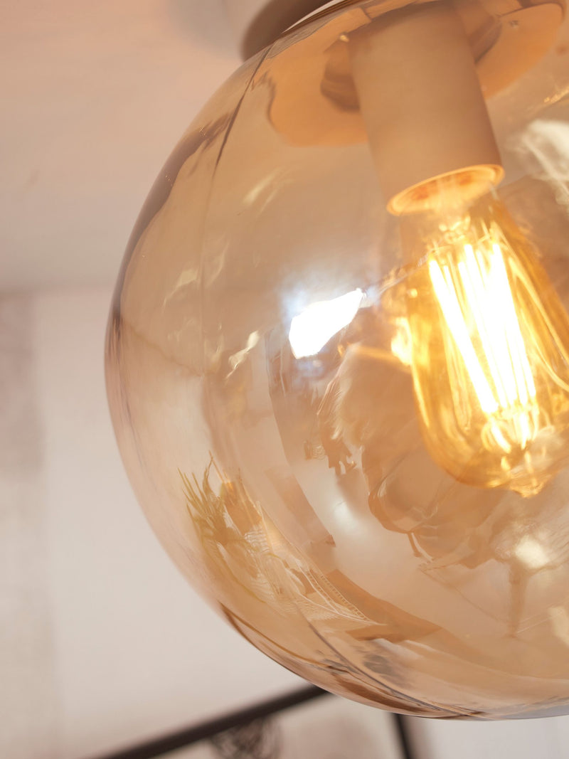 RoMi Deckenleuchte Helsinki aus Eisen in Bernstein: Detail des runden Bernsteinglasschirms mit Glühlampe.