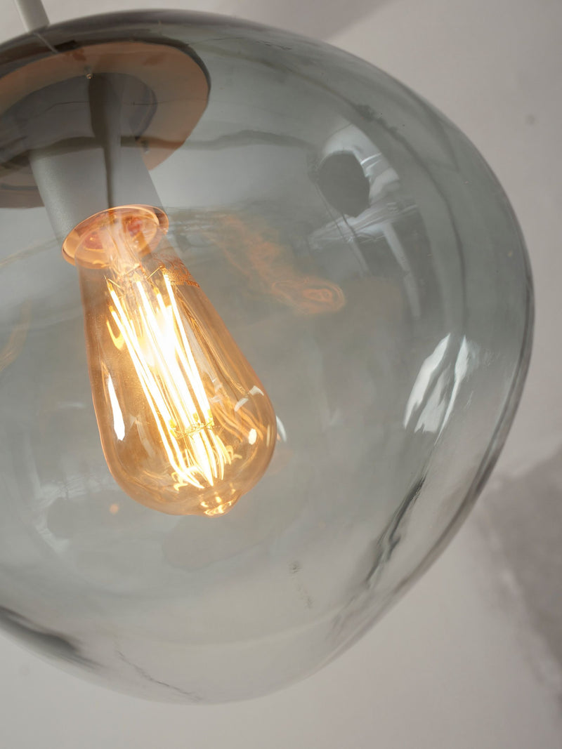 RoMi Hängeleuchte Helsinki aus Glas: Detailansicht des hellgrauen Glasschirms mit Edison-Glühbirne und Eisengestell.