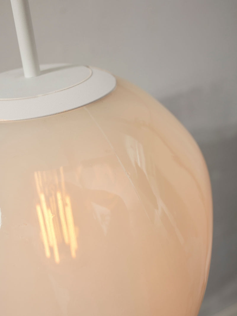 Detailaufnahme der milchweißen Glaskugel der Hängeleuchte It's about RoMi Helsinki mit weißem Eisengestell und Lichtreflexen.