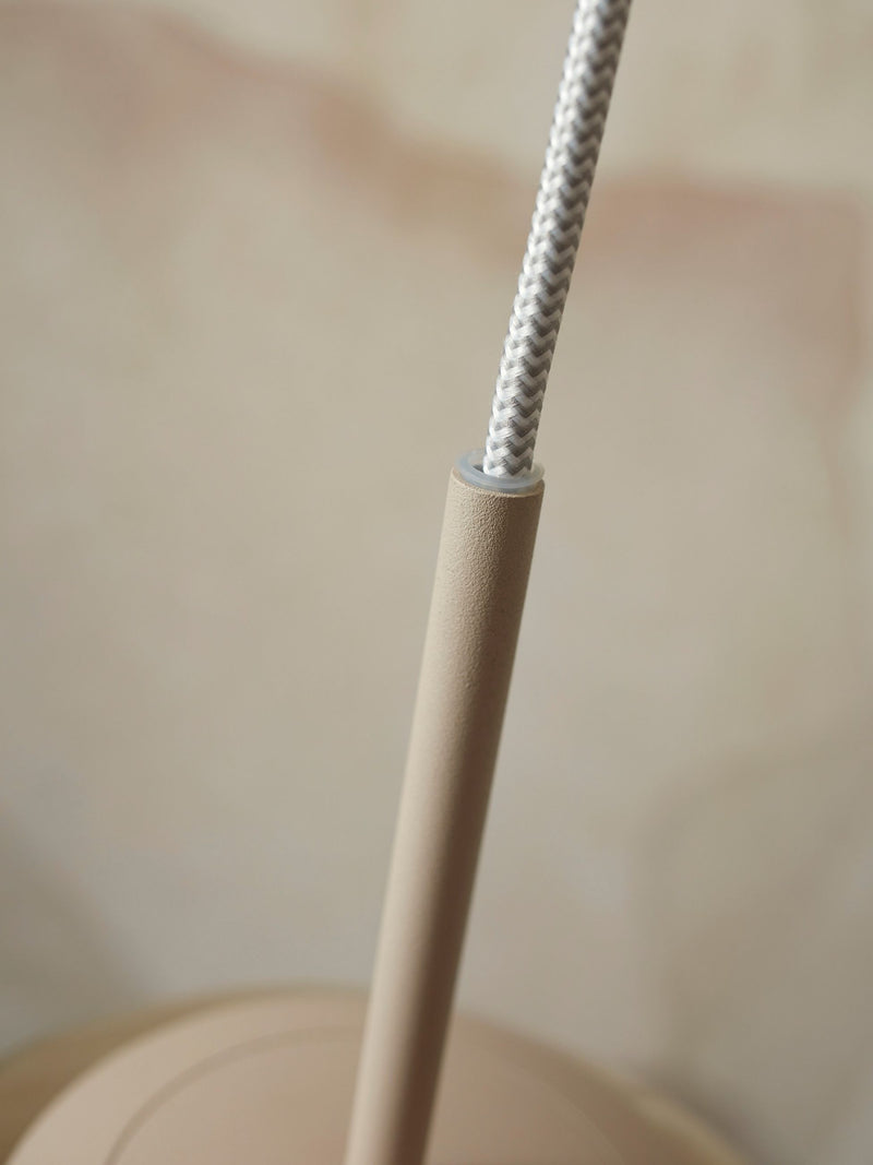 Detailaufnahme des beige lackierten Metallgestells der Hängeleuchte It's about RoMi Helsinki, aus dem ein graues Textilkabel austritt.