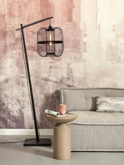 Stehleuchte Hokkaido aus schwarzem Bambus mit käfigartigem Schirm, daneben beige Beistelltisch und Sofa.