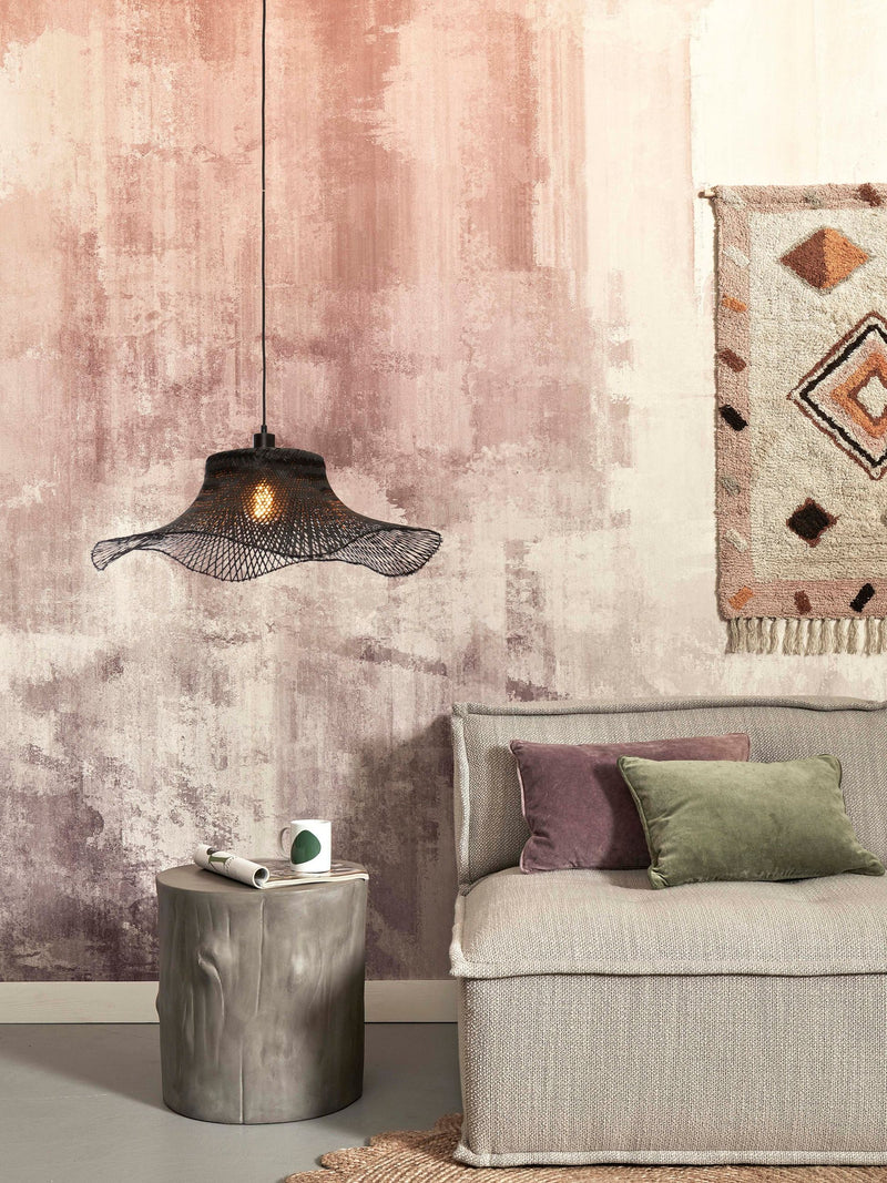 Good&Mojo Hängeleuchte Ibiza aus schwarzem Bambus mit wellenförmigem Schirm, über einem Sofa in einem Wohnraum mit rosa Wand.