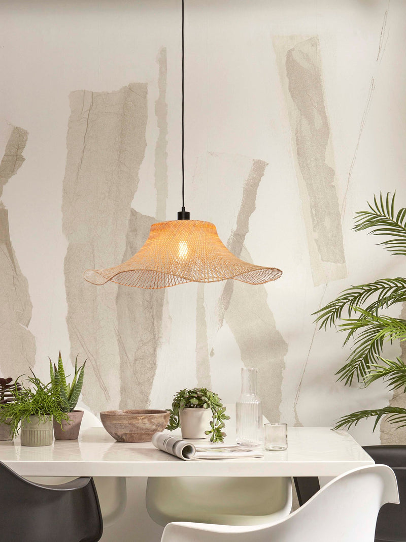 Hängeleuchte Ibiza von Good&Mojo aus geflochtenem Bambus in Naturfarbe mit welligem Schirmrand, über einem weißen Esstisch.