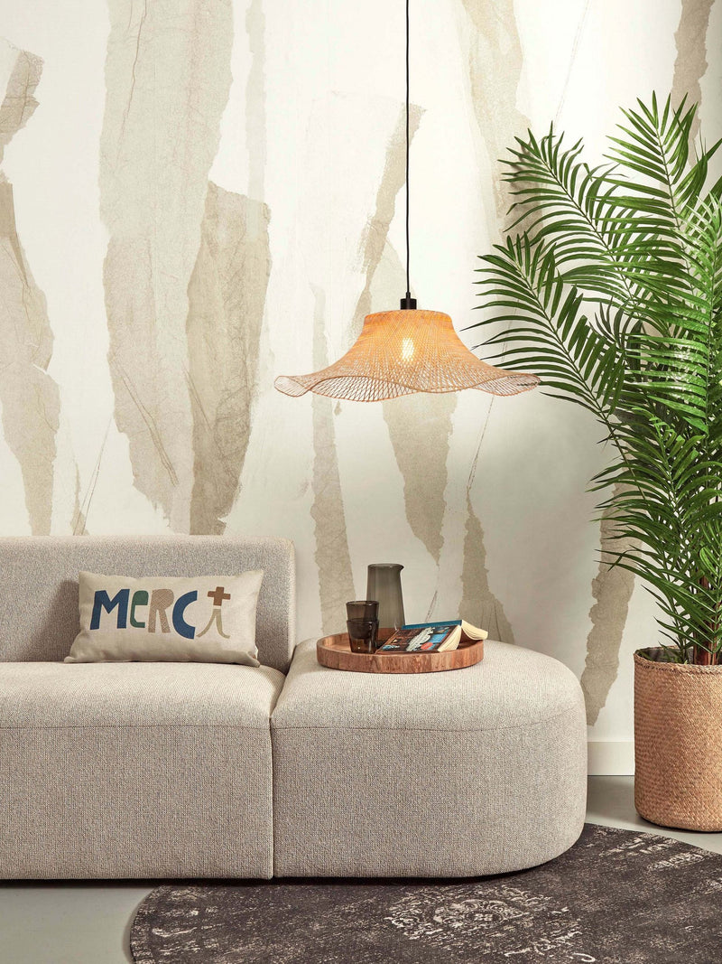 Good&Mojo Hängeleuchte Ibiza aus Bambus mit geschwungenem Geflechtschirm, hängt über einem beigen Sofa.