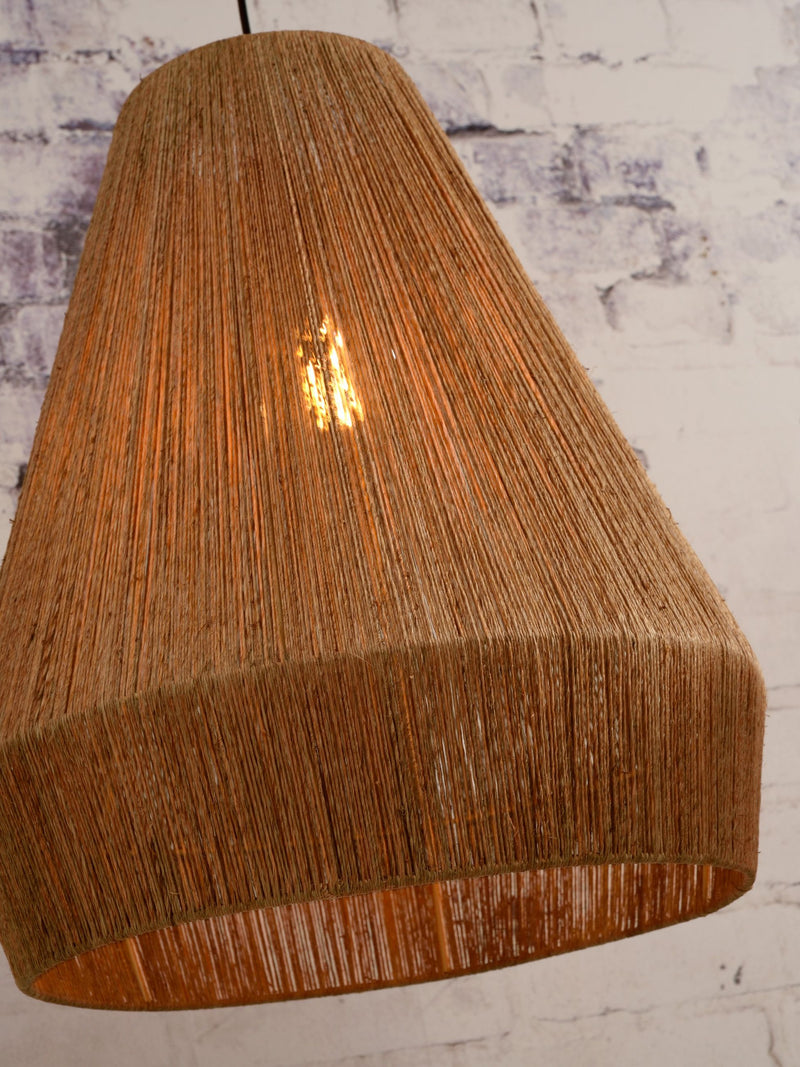 Hängeleuchte Iguazu von Good&Mojo mit Lampenschirm aus naturfarbener Jute, durch den das warme Licht der Glühbirne schimmert.
