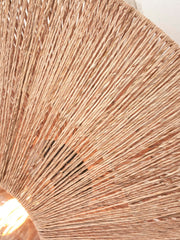 Detailaufnahme des Schirms der Good&Mojo Wandleuchte Iguazu aus Jute mit radialem Flechtmuster in Naturton und durchscheinendem Licht.