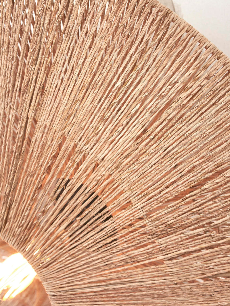 Detailaufnahme des Schirms der Good&Mojo Wandleuchte Iguazu aus Jute mit radialem Flechtmuster in Naturton und durchscheinendem Licht.