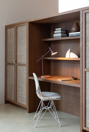 Schreibtisch-Nook mit Holzregal und Geflechtkästen, daneben bordeauxrote Tischleuchte von It's about RoMi.