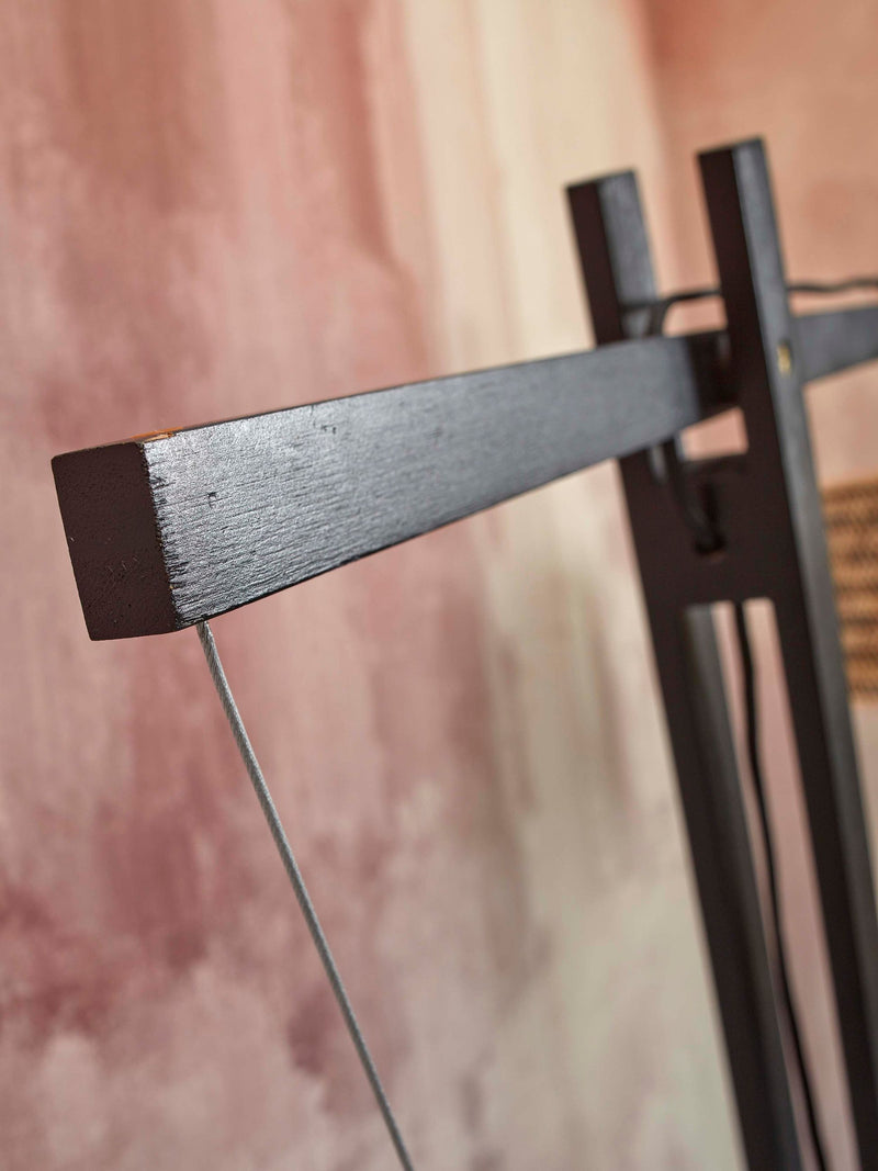 Detailansicht der schwarz lackierten Querstrebe der Good&Mojo Stehleuchte Java XL mit Bambusgestell vor rosafarbener Wand.