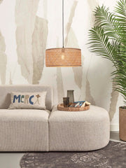 Hängeleuchte Java von Good&Mojo mit geflochtenem Bambusschirm über einem hellen Sofa in einem Wohnraum.