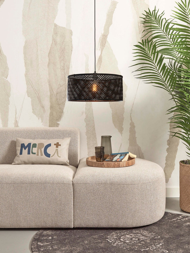 Good&Mojo Hängeleuchte Java in Schwarz hängt über einem Sofa; der geflochtene Bambusschirm lässt warmes Licht durch.