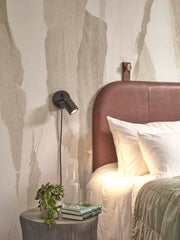 Gesamtansicht Schlafzimmer: Good&Mojo Wandstrahler Java mit schwarzem Bambusgestell neben braunem Lederkopfteil.