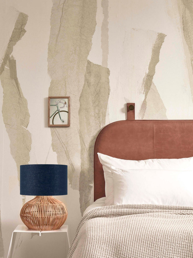 Tischleuchte Kalahari von Good&Mojo mit geflochtenem Rattanfuß und blauem Leinenschirm auf einem Beistelltisch.