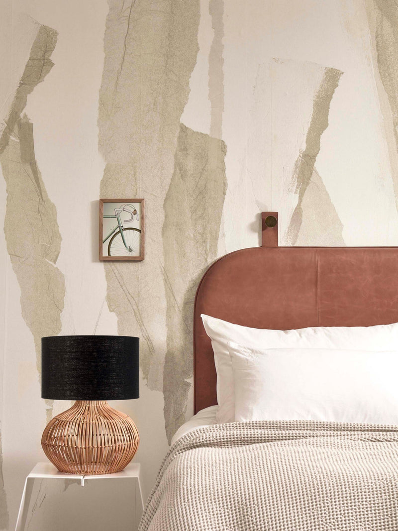 Tischleuchte Kalahari von Good&Mojo mit schwarzem Leinenschirm und Rattanfuß auf einem weißen Beistelltisch neben dem Bett.