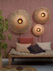 Good&Mojo Wandleuchte Kalimantan aus Bambus: drei runde Leuchten mit Naturbambus-Geflecht an rosafarbener Wand, darunter ein Daybed.