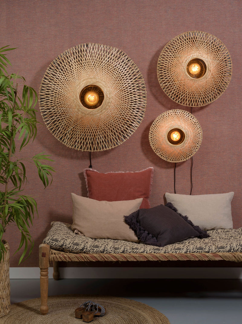 Good&Mojo Wandleuchte Kalimantan aus Bambus: drei runde Leuchten mit Naturbambus-Geflecht an rosafarbener Wand, darunter ein Daybed.