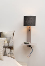 Wandleuchte Florence mit schwarzem Leinenschirm, sandfarbenem Eisengestell, Ablage und flexibler Leselampe vor heller Wand.