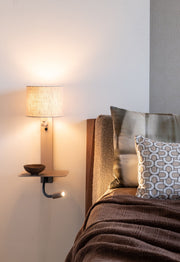 Wandleuchte Florence mit Leselampe: heller Leinenschirm, Ablage und schwenkbare Leselampe am Bett.
