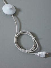 Detailaufnahme des weißen Zwischenschalters am gewebten Kabel der RoMi Stehleuchte Lisbon mit spitzem Eisenschirm.