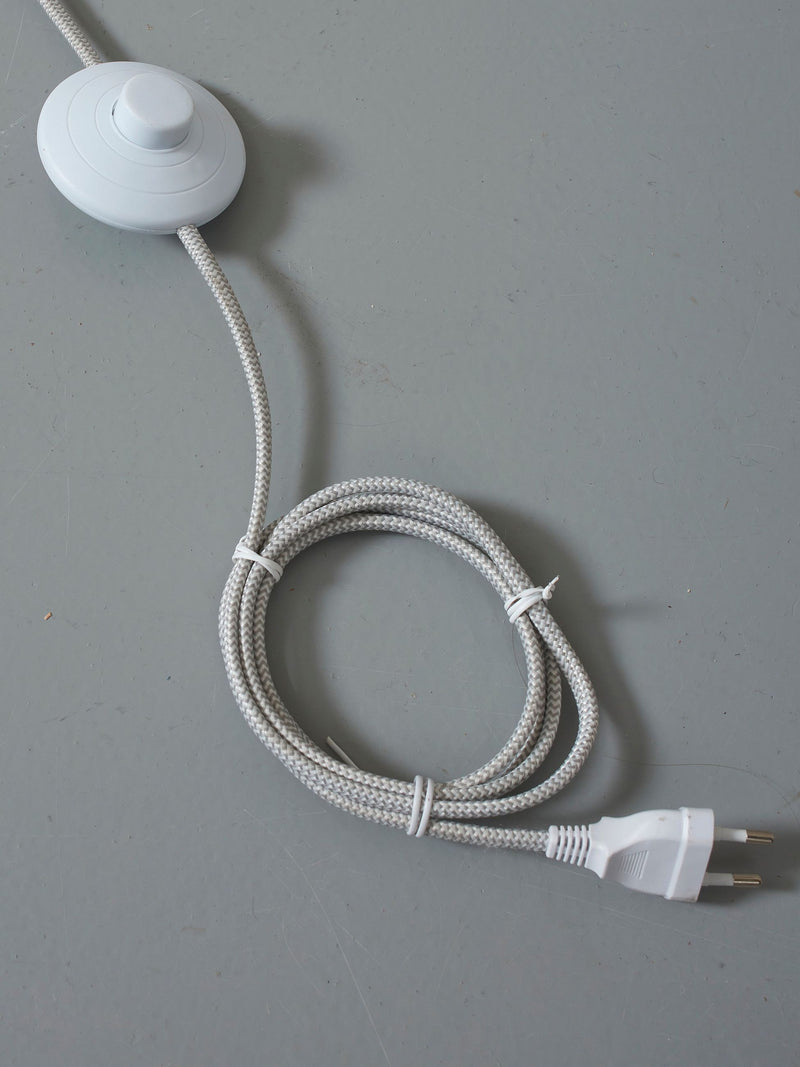 Detailaufnahme des weißen Zwischenschalters am gewebten Kabel der RoMi Stehleuchte Lisbon mit spitzem Eisenschirm.