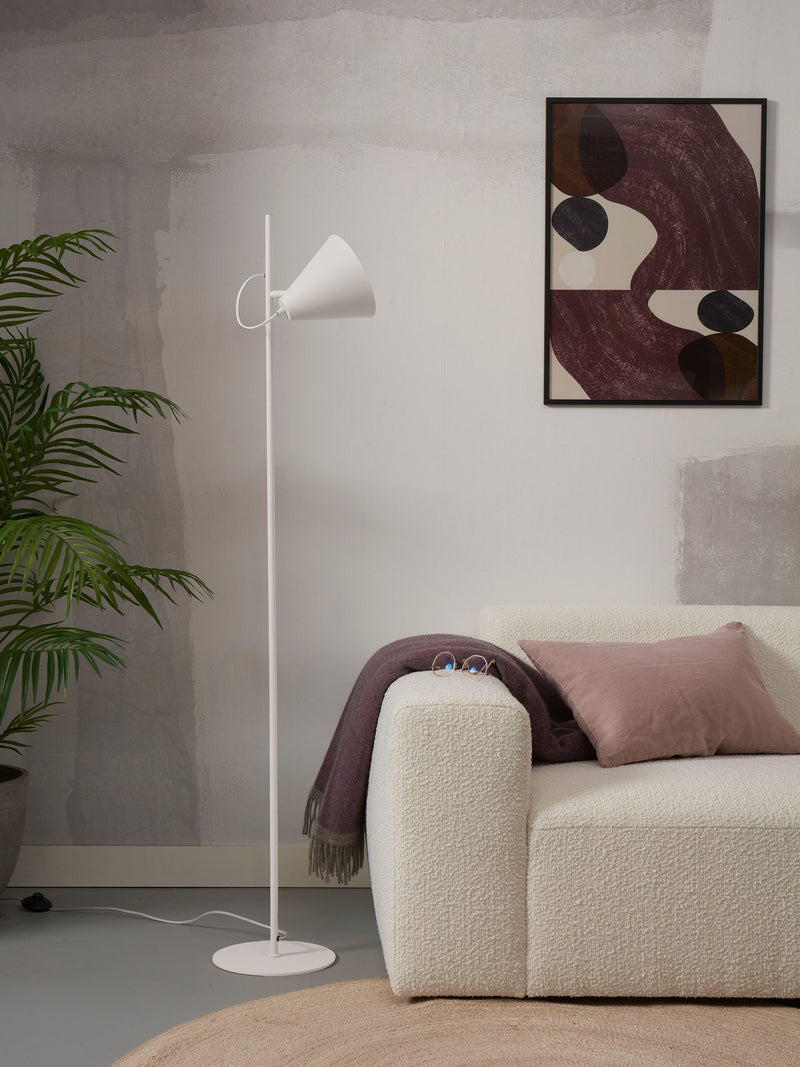 Stehleuchte RoMi Lisbon mit spitzem Eisenschirm in Weiß, daneben ein cremefarbenes Sofa mit rosa Kissen.