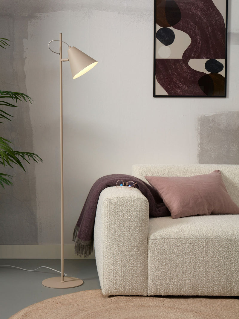 It’s about RoMi Stehleuchte Lisbon mit spitzem Schirm aus Eisen in Sand, neben einem cremefarbenen Bouclé-Sofa im Wohnraum.