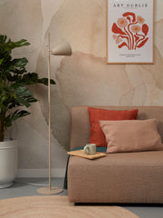 Stehleuchte Lisbon von It's about RoMi in Sand mit spitzem Eisenschirm, neben Sofa und Monstera im Wohnraum.