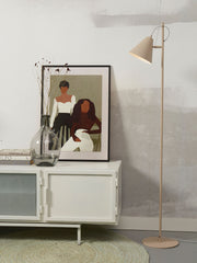 It’s about RoMi Stehleuchte Lisbon mit spitzem Schirm aus Eisen in Sand, neben einem weißen Sideboard und einem Kunstdruck.
