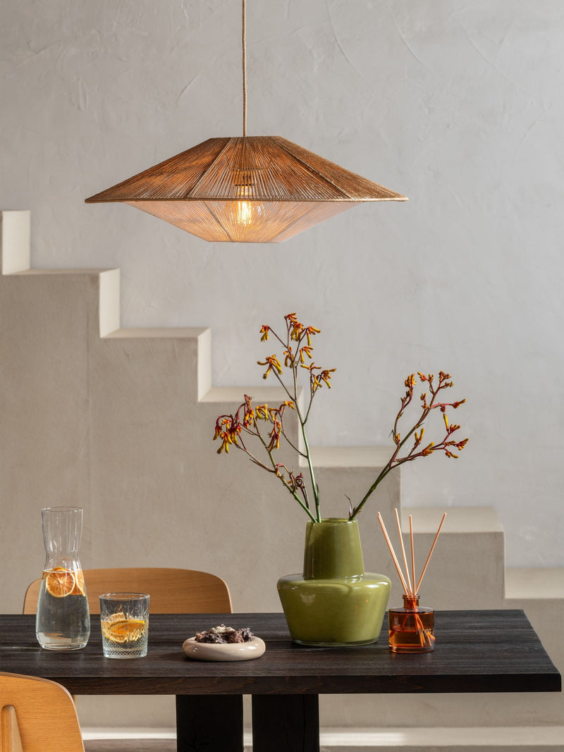 Hängeleuchte Lumbini von Good&Mojo aus Papierseil in Natur über einem Esstisch mit Vase und Karaffe.