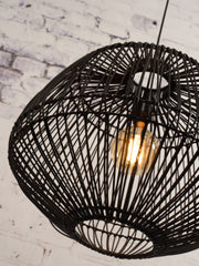 Hängeleuchte Madagascar von Good&Mojo aus schwarzem Rattan mit offenem Geflecht, im Detail mit leuchtender Glühbirne.