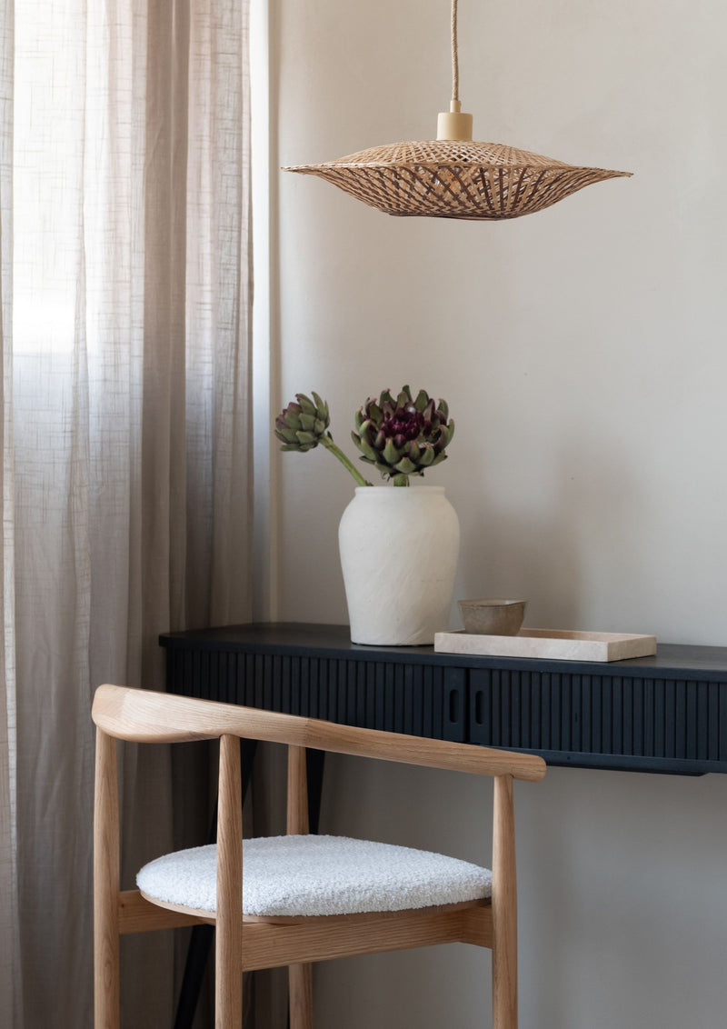 Hängeleuchte Madura von Good&Mojo aus Bambus in Erdtönen über einem Sideboard mit Keramikvase und Blumen.