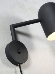 RoMi Wandleuchte Marseille in Schwarz: Detailansicht des schwarzen Metallarms, Wandsockels mit Schalter und Lampenschirms.
