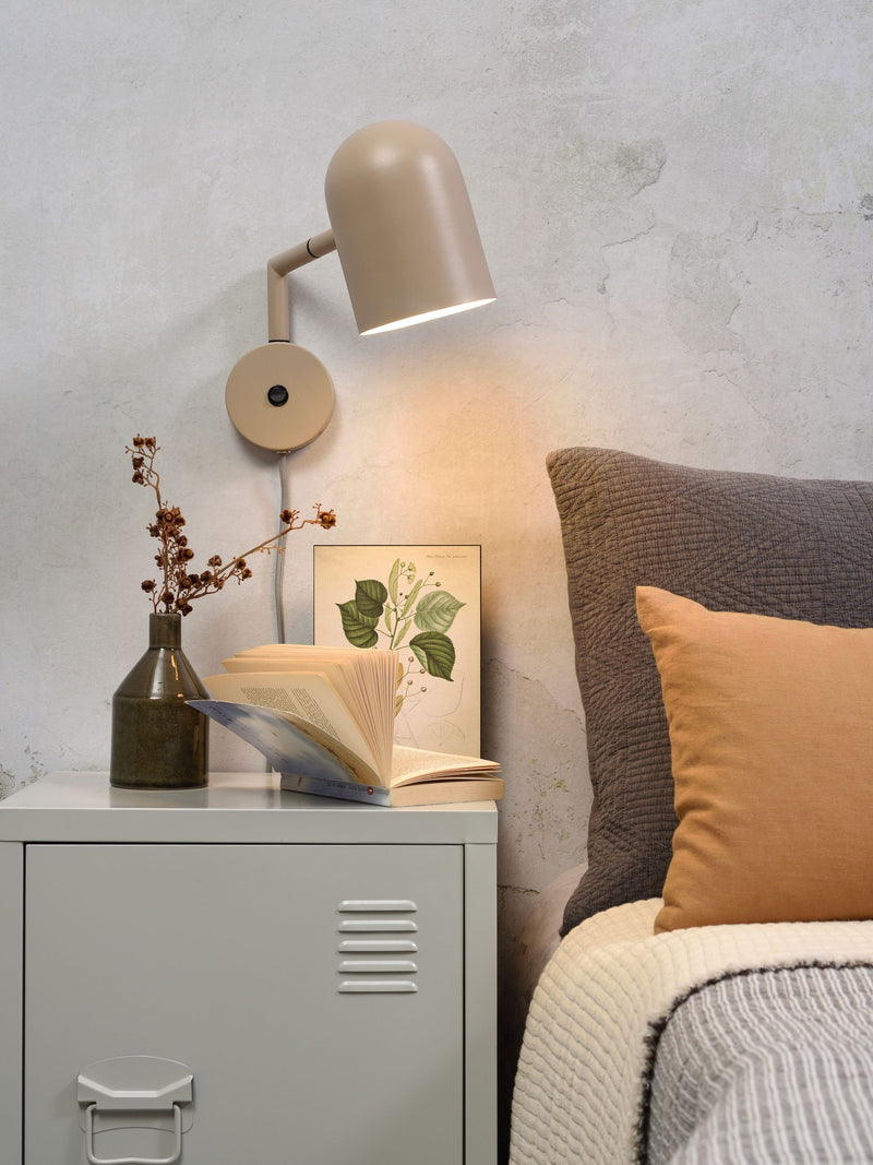 It's about RoMi Wandleuchte Marseille in Sand, mit schwenkbarem Schirm über einem grauen Metallnachttisch am Bett.