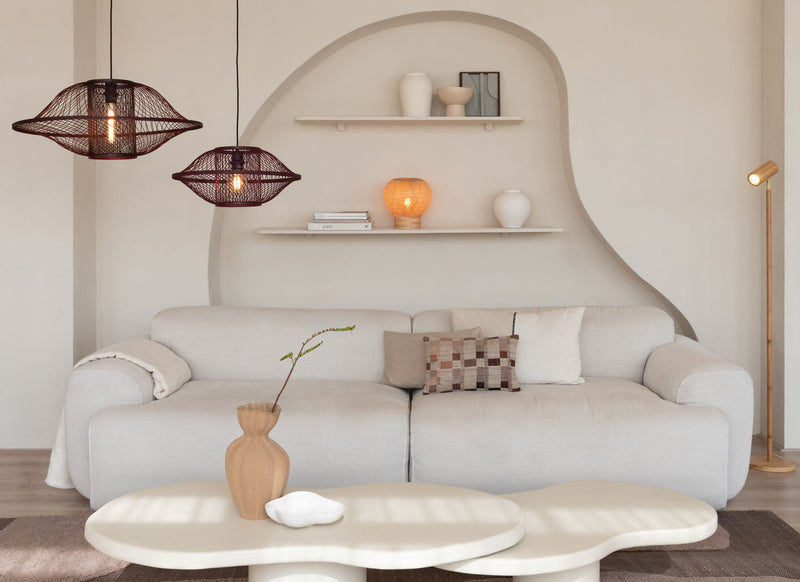 Zwei weinrote Hängeleuchten Maui von Good&Mojo mit Bambusschirm hängen über einer hellen Couch im Wohnzimmer.